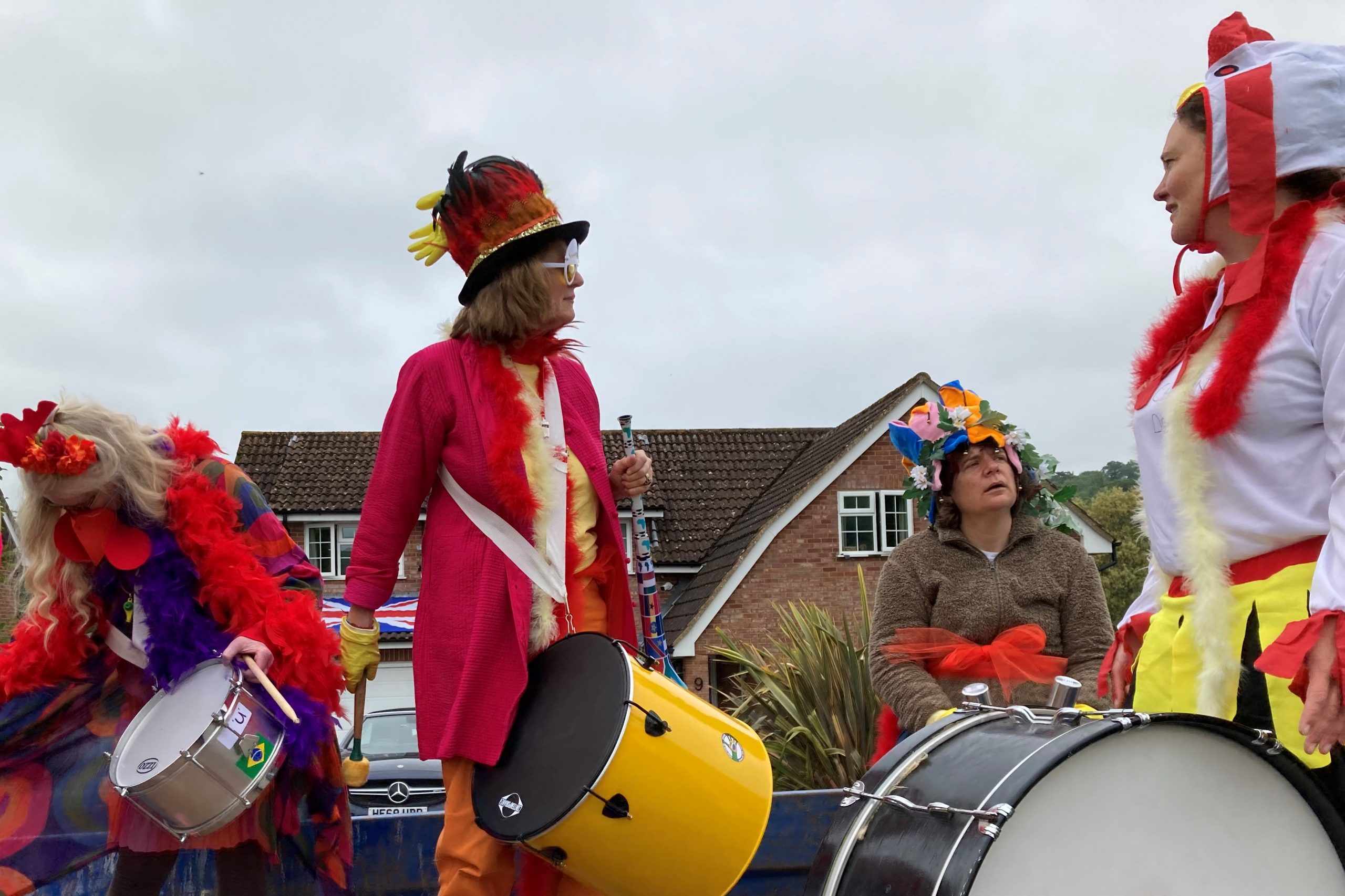 People in decorative red garments holding large drums