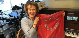 Cheerful group leader Emma holds up magic bag and smiles