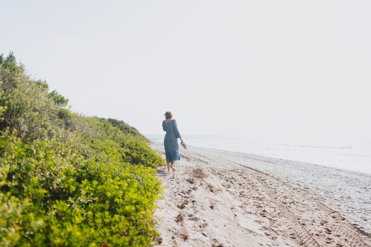 Relaxing picture of a woman walking barefoot in the sand