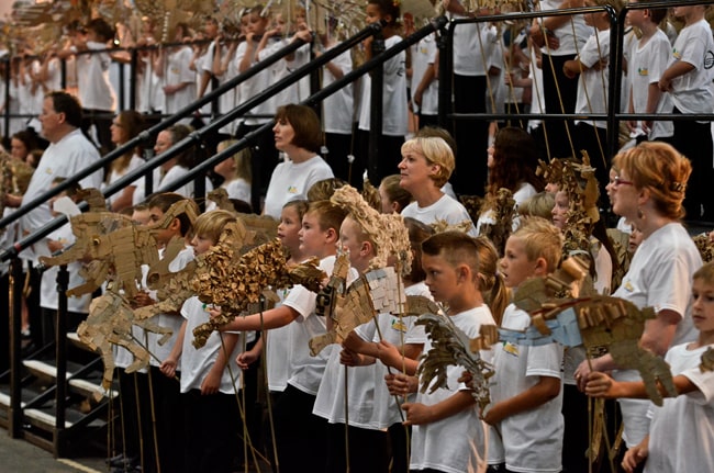 Children and adults dressed in white t shirts, simging