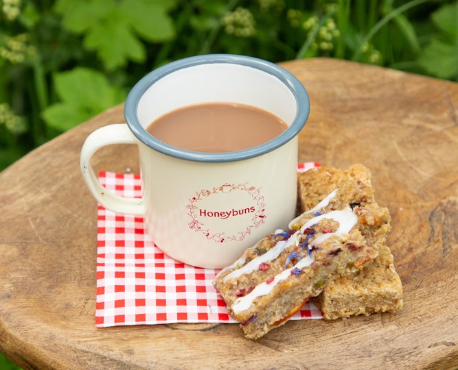 tea in a mug marked 'honeybuns' with cakes to the side