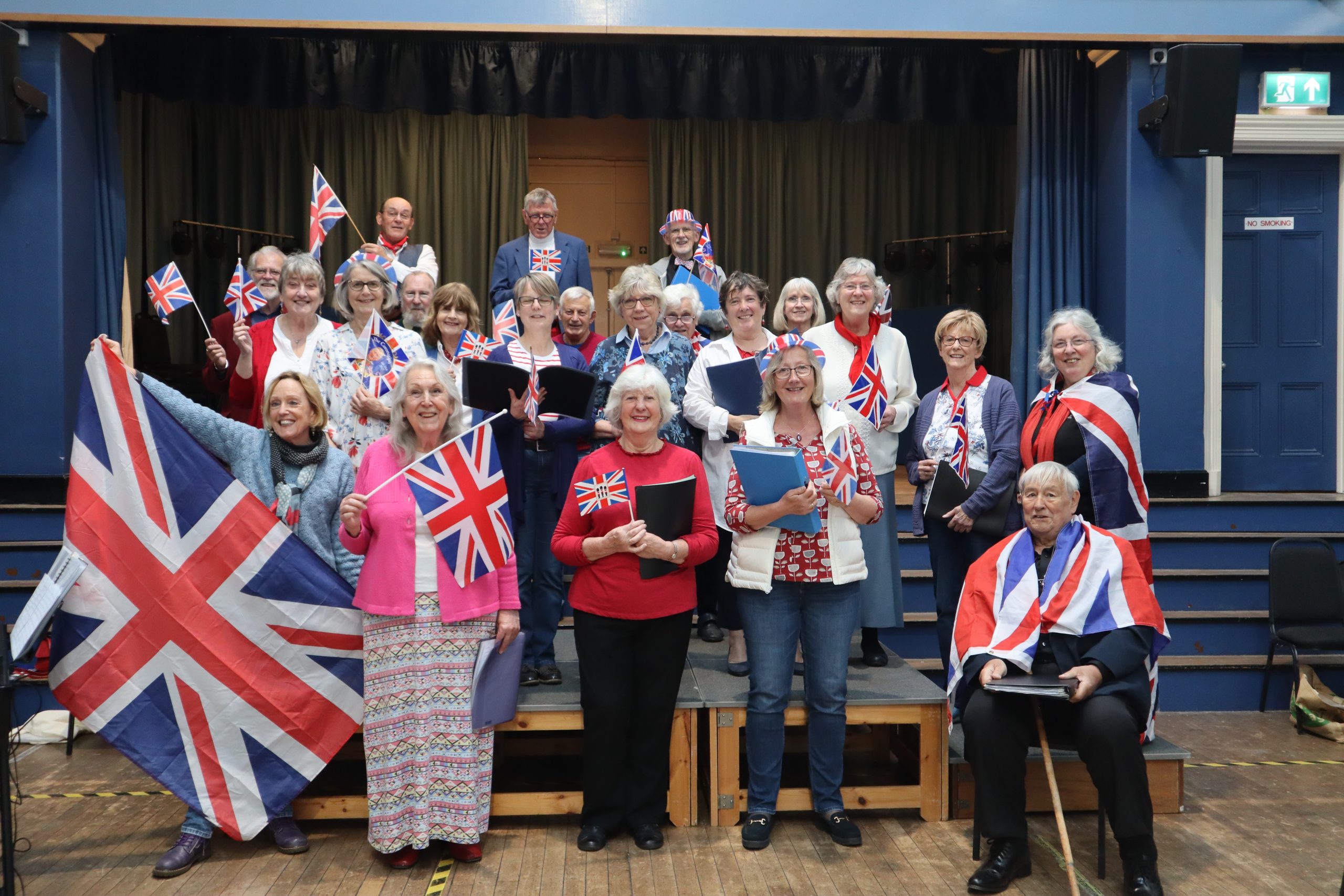 Group of adults stand holding union jack flags